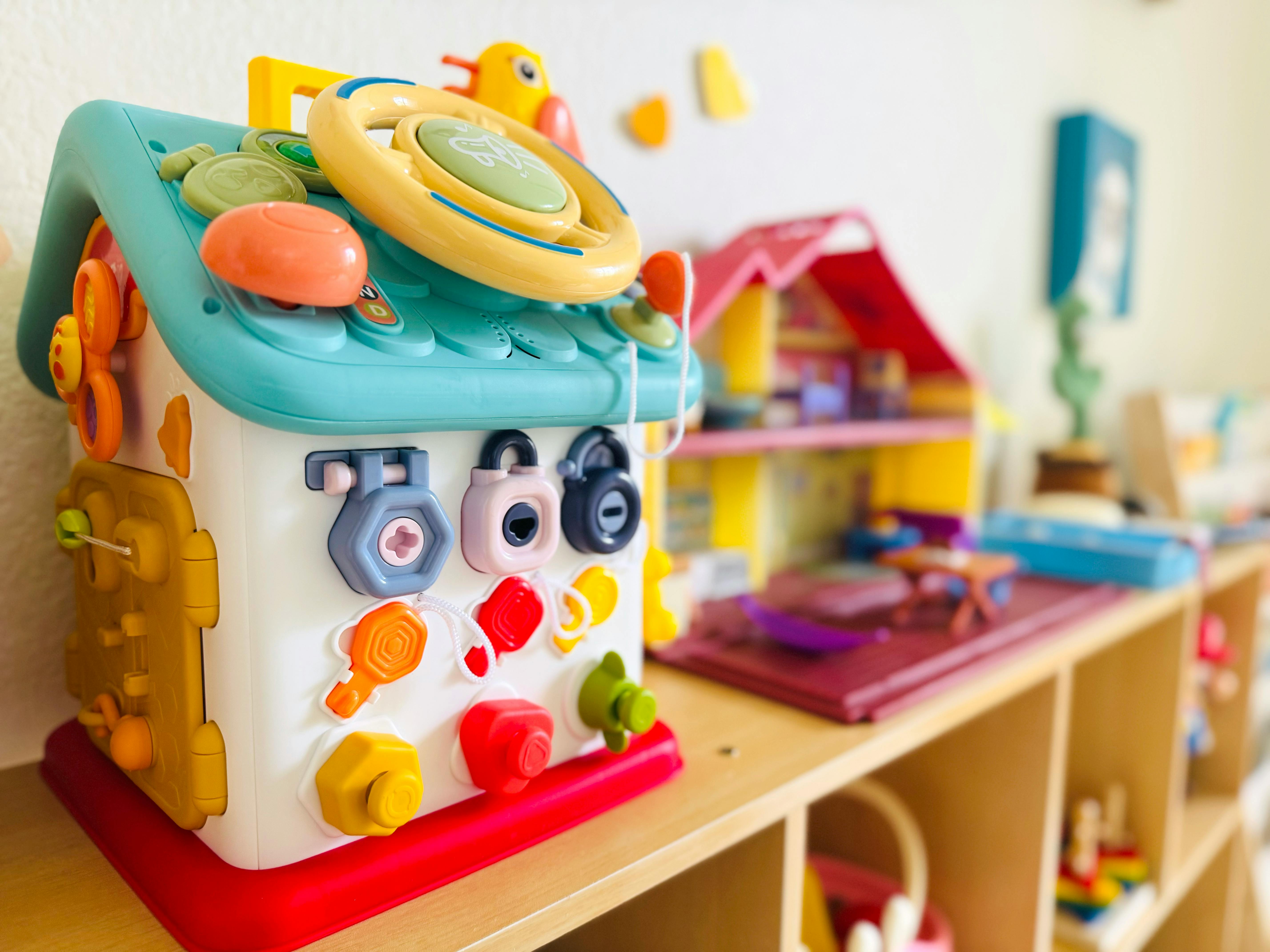 Toy house with colorful shapes and locks on a shelf
