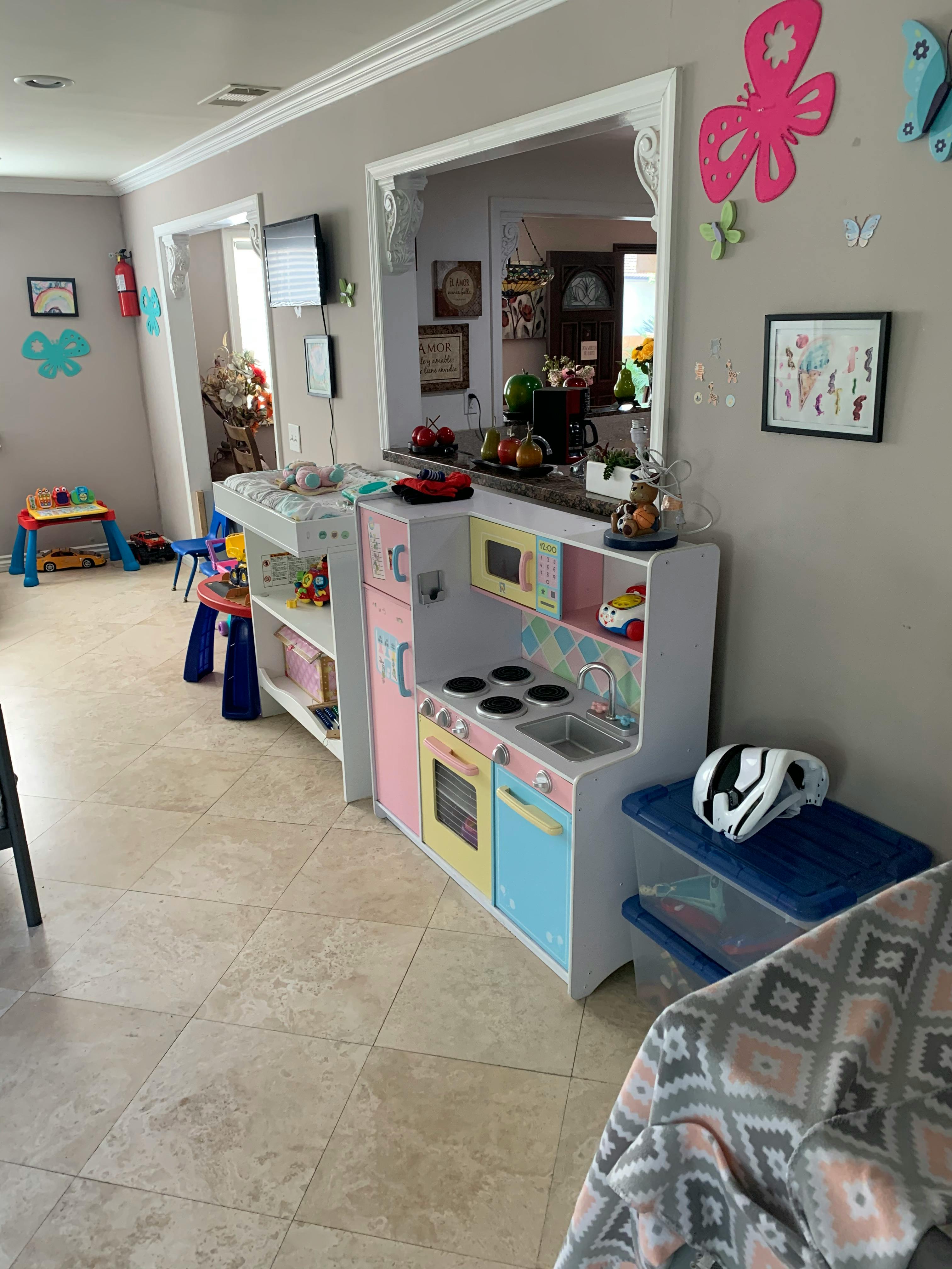 Child's play kitchen set in a room with tiled floor