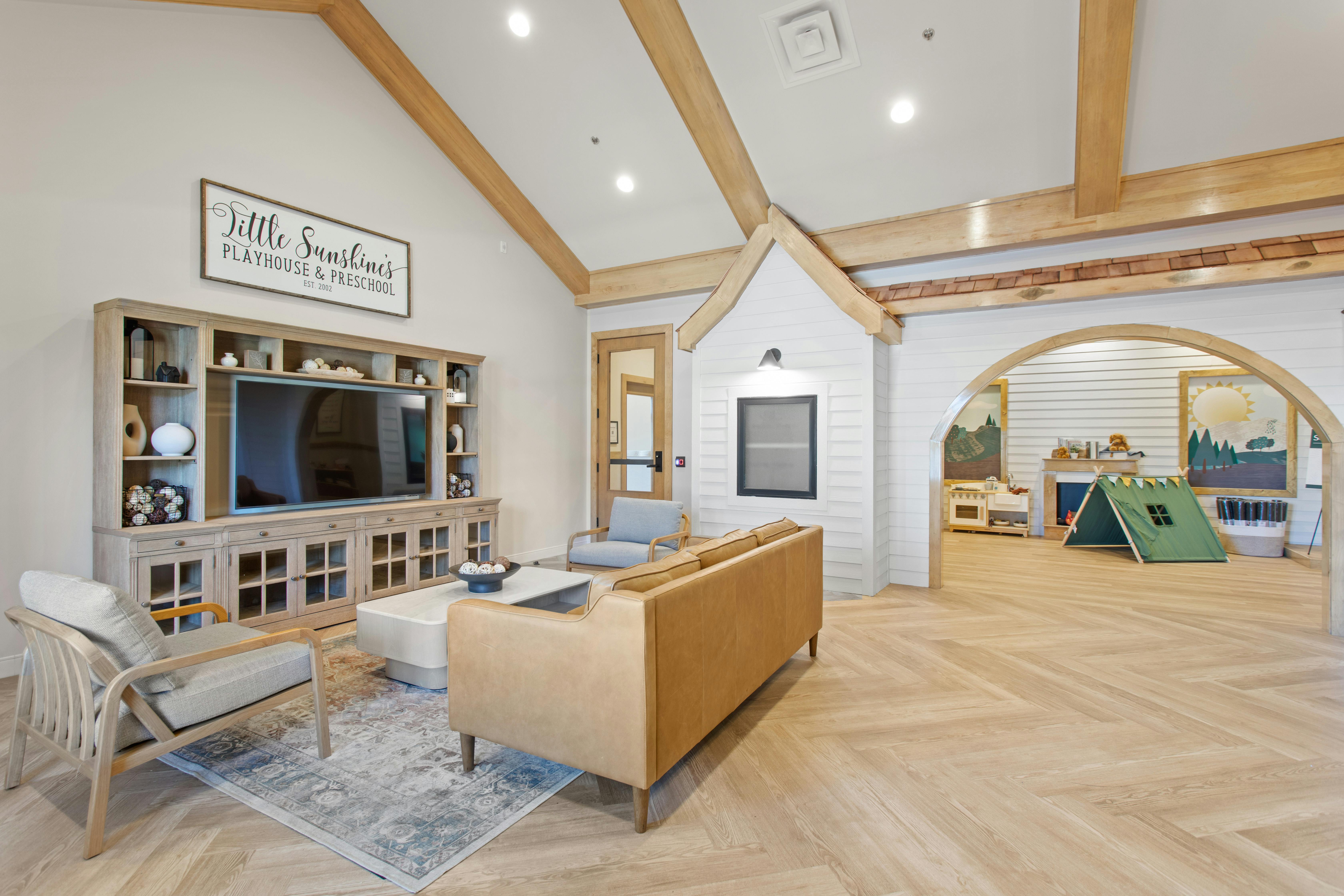 Living room with a TV, sofa, and a play area with a tent