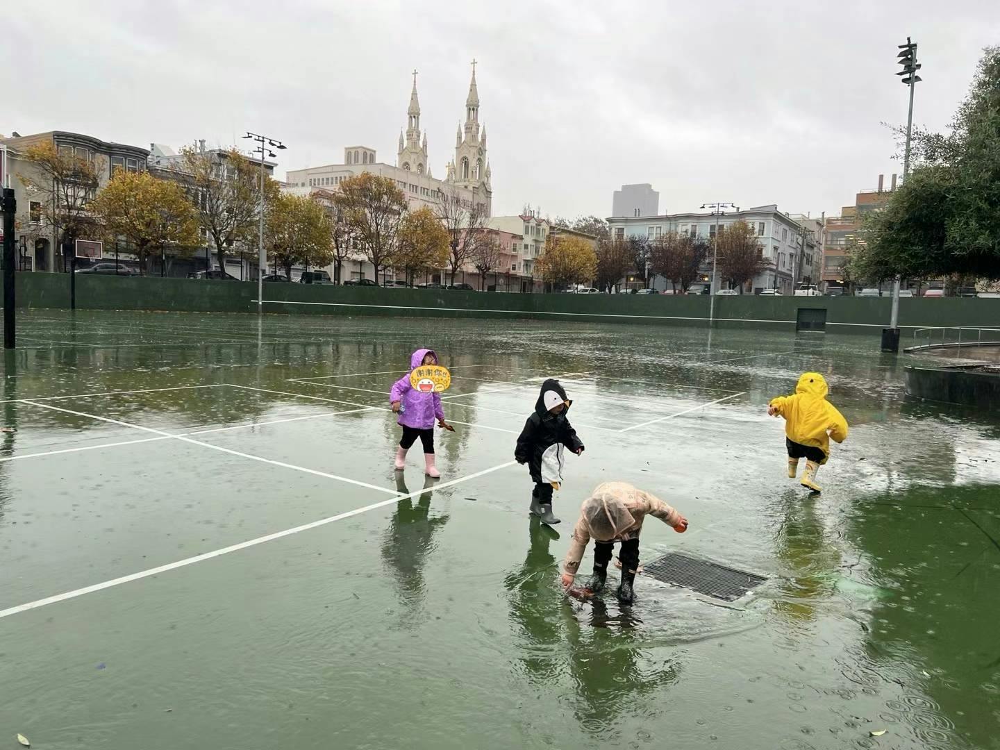 Children playing in a flooded tennis court