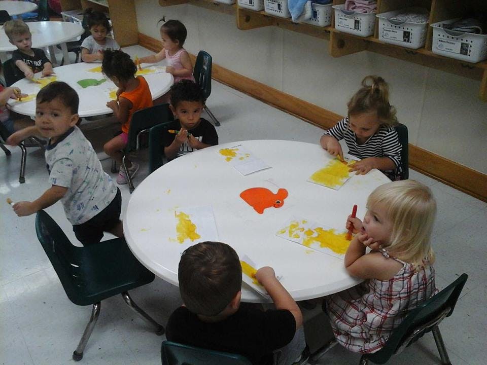Children at tables in a classroom doing an art activity