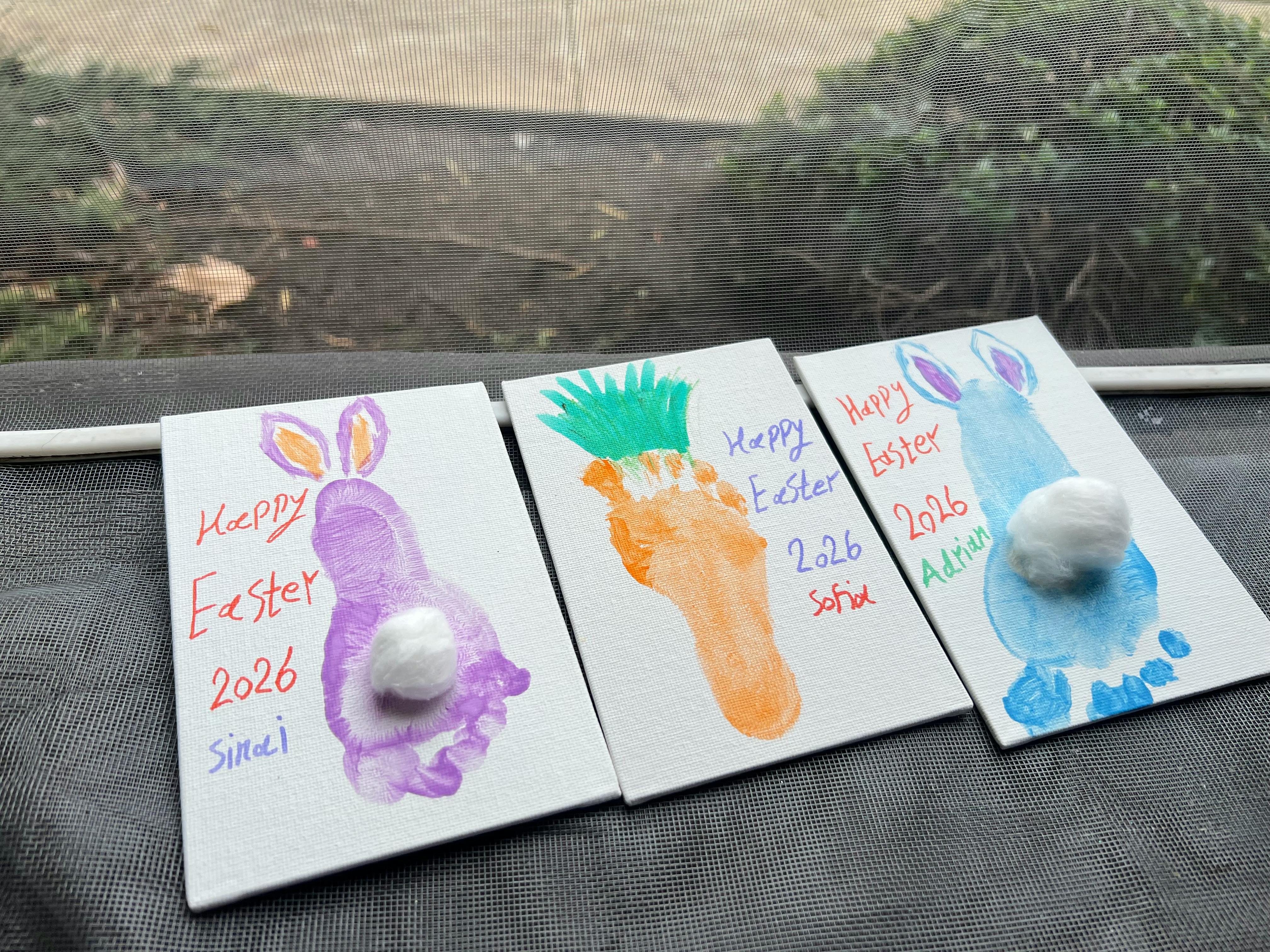 Three children's footprint art pieces, each with "Happy Easter 2026" and a name