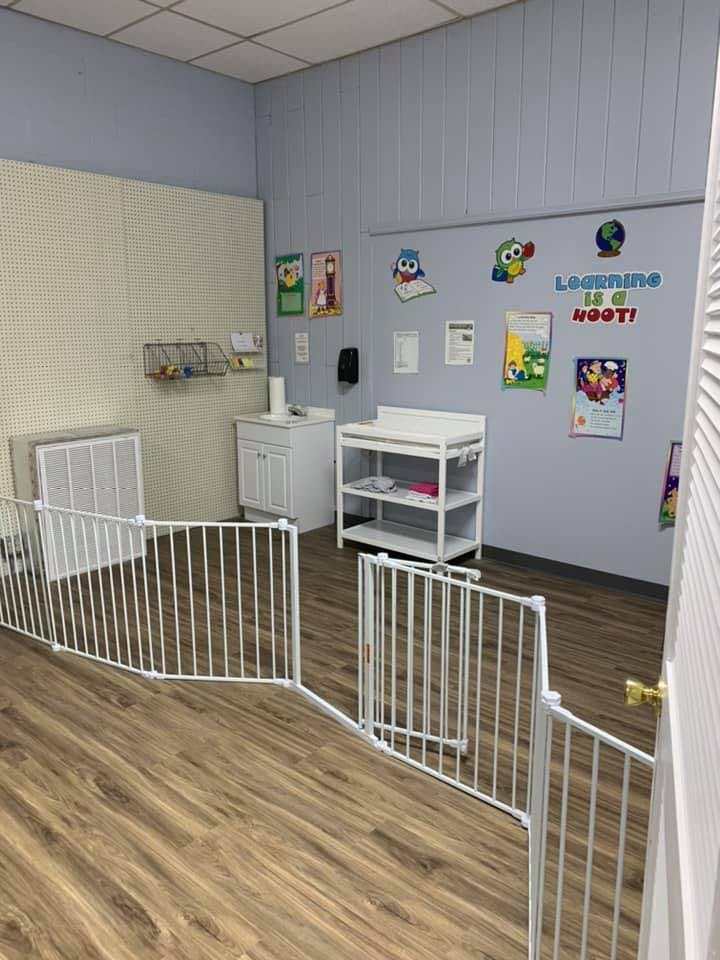 Child-safe room with a changing table, sink, and playpen