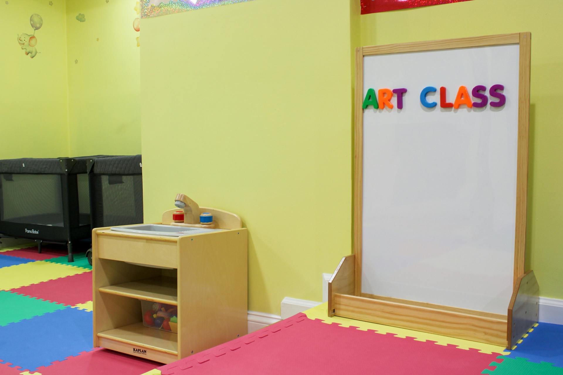 Whiteboard with "ART CLASS" spelled out in colorful magnetic letters