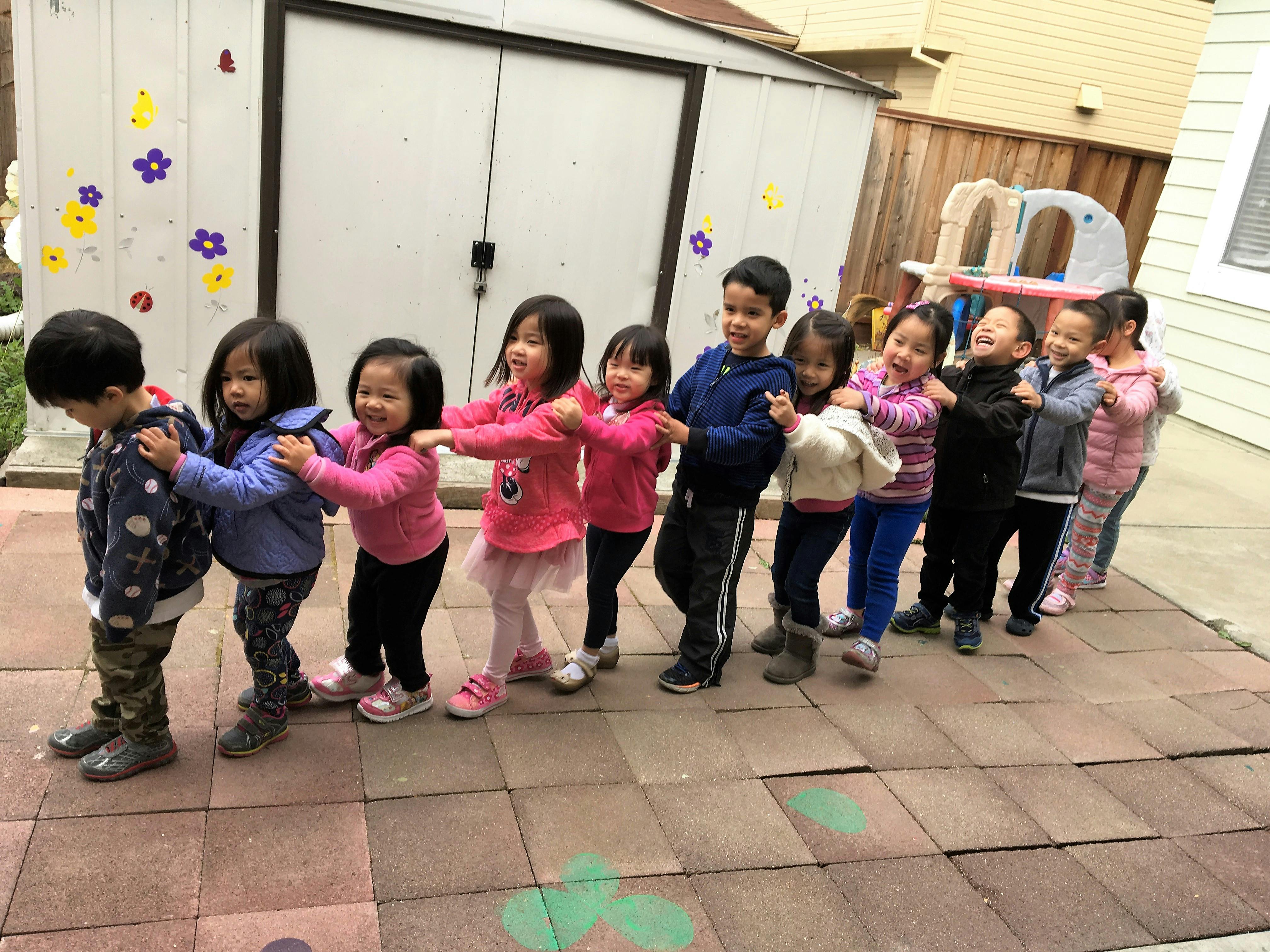 Line of children holding onto each other's shoulders