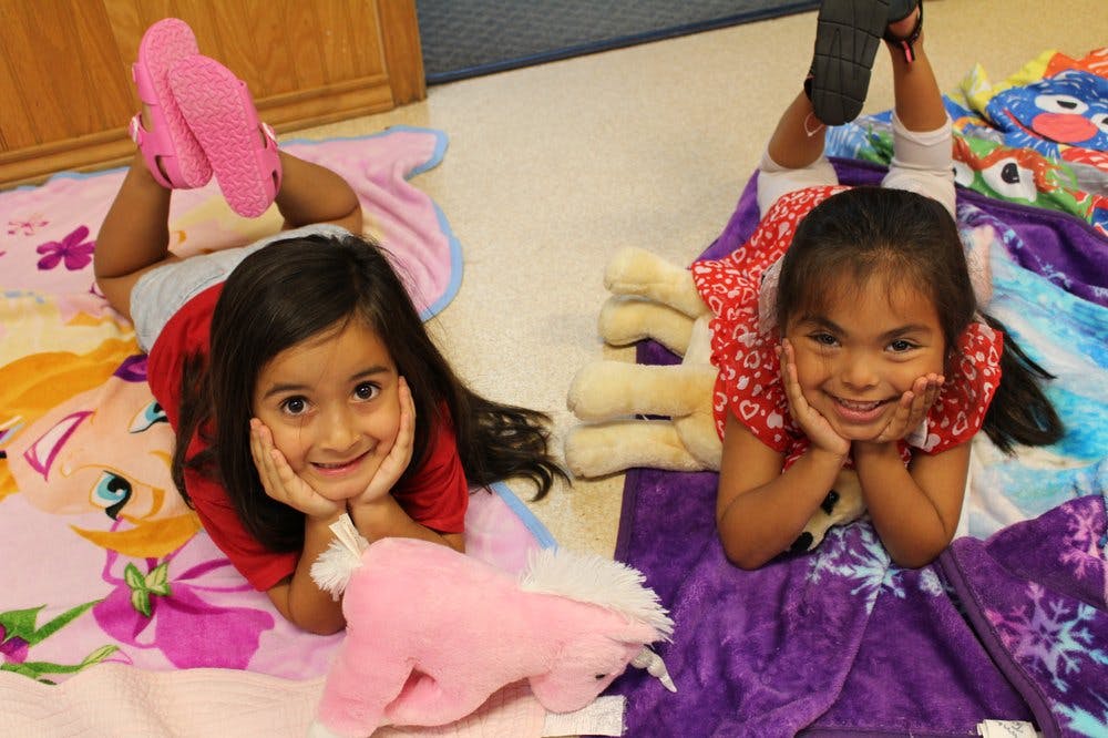 Two children lying on blankets on the floor