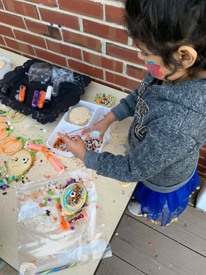 Child decorating cookies with sprinkles and icing