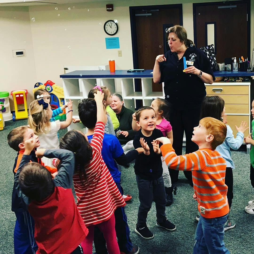 Adult blowing bubbles for a group of children