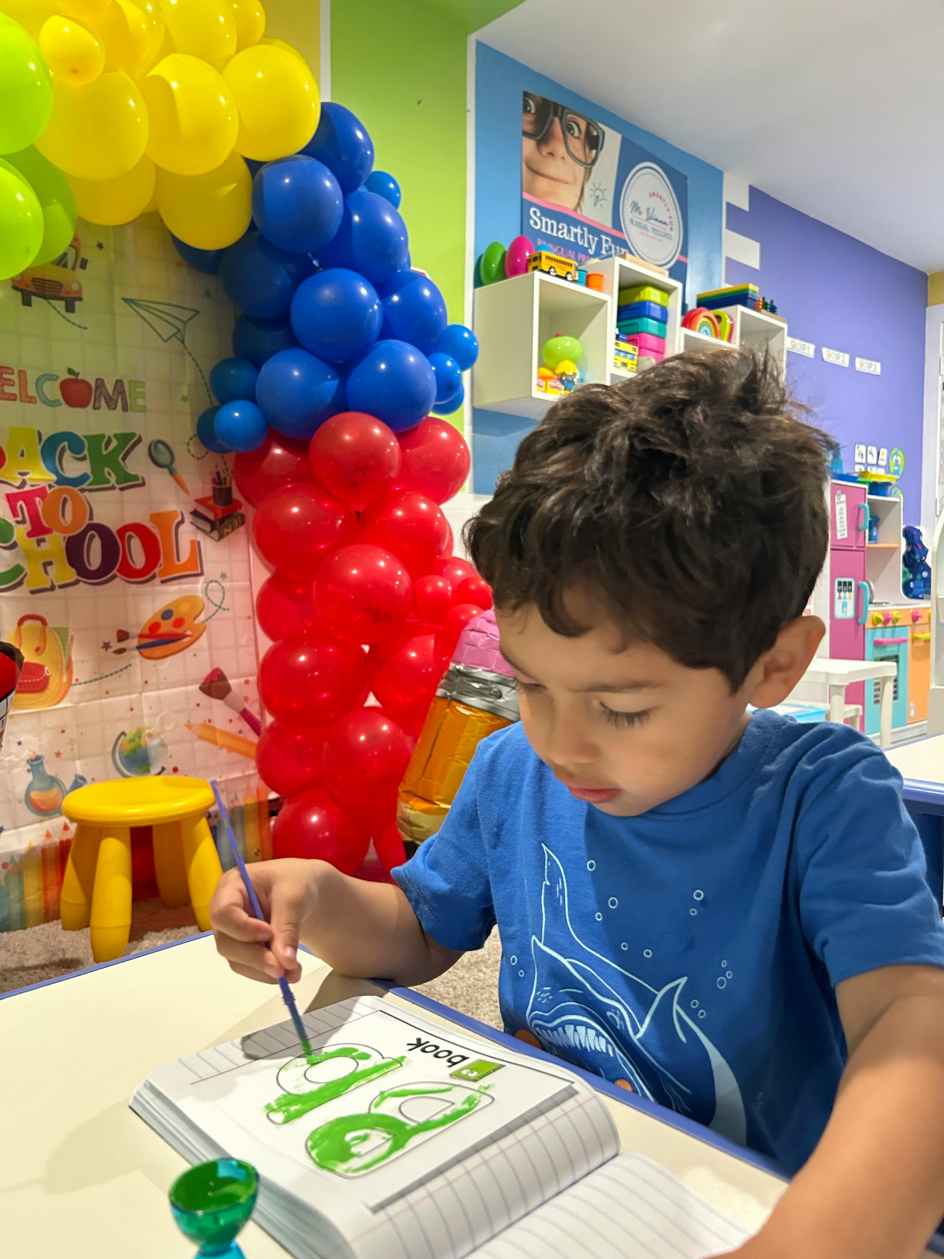 Child drawing in a notebook with a pencil in a classroom