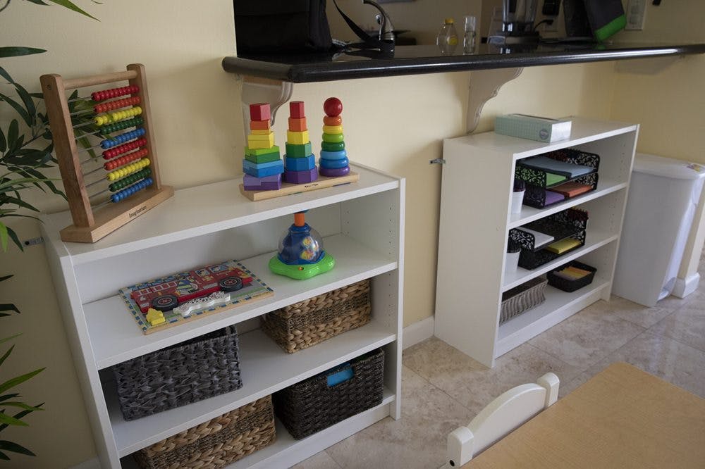 Two white bookshelves with toys and baskets