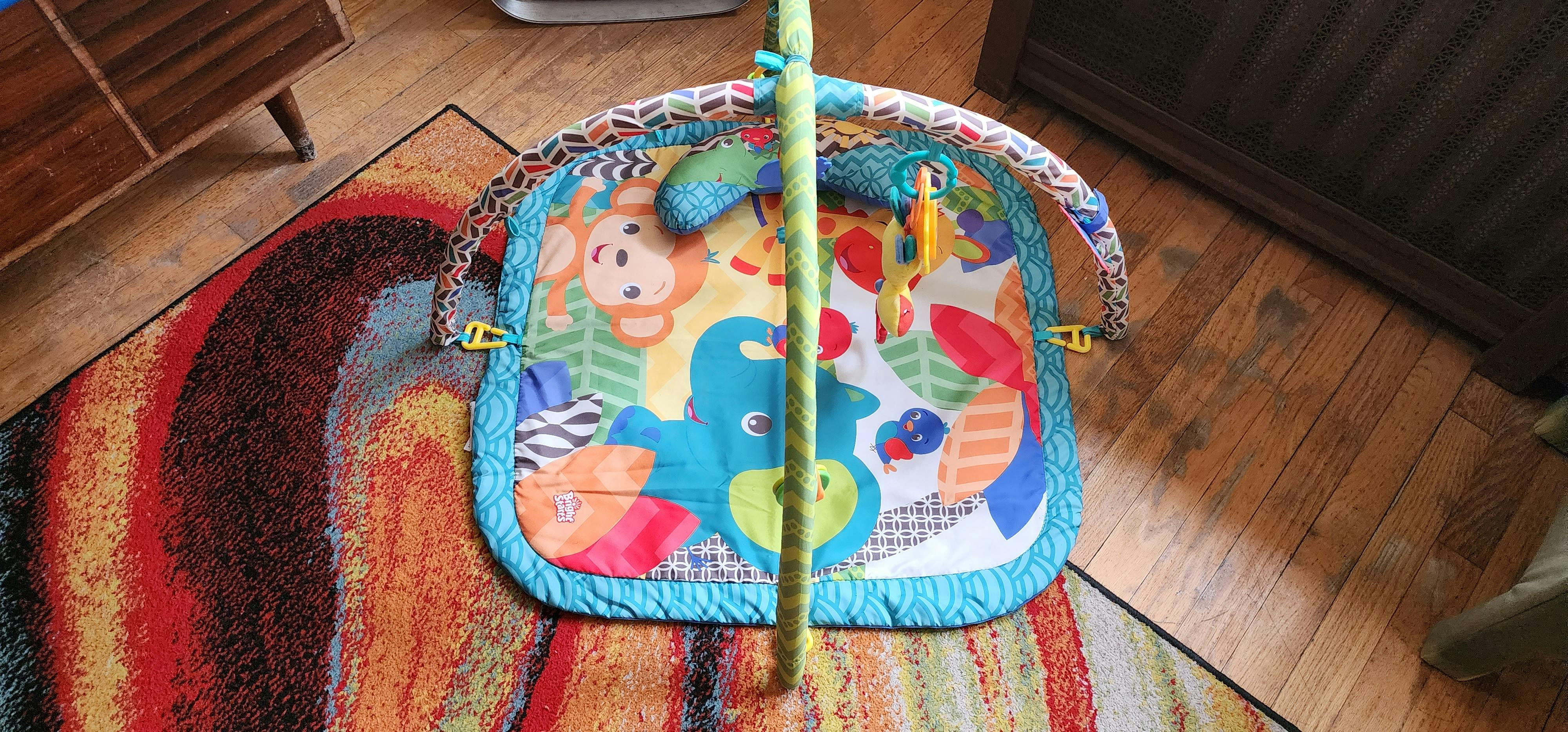 Colorful baby playmat with animal designs and hanging toys
