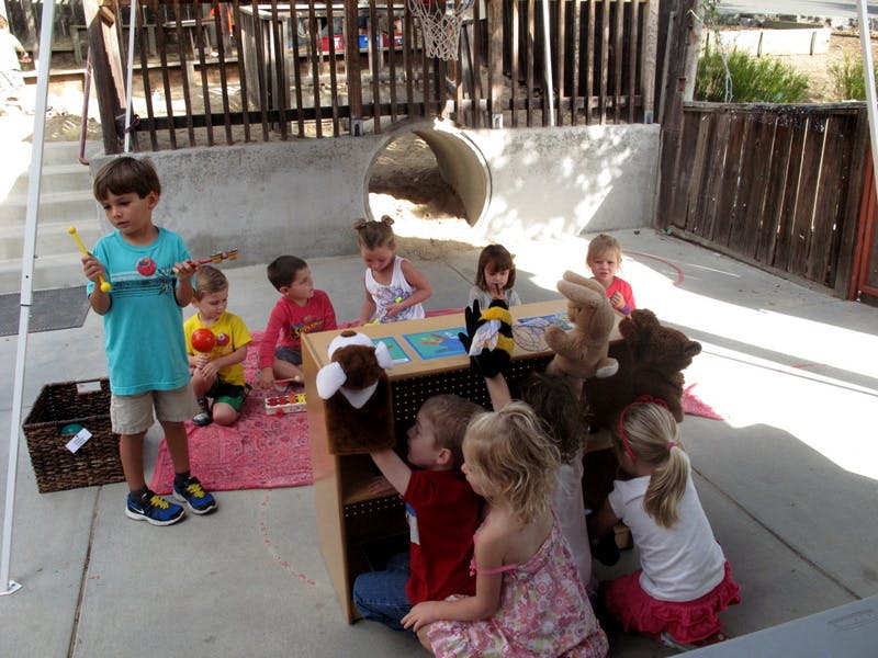 Children playing with puppets and toys outdoors