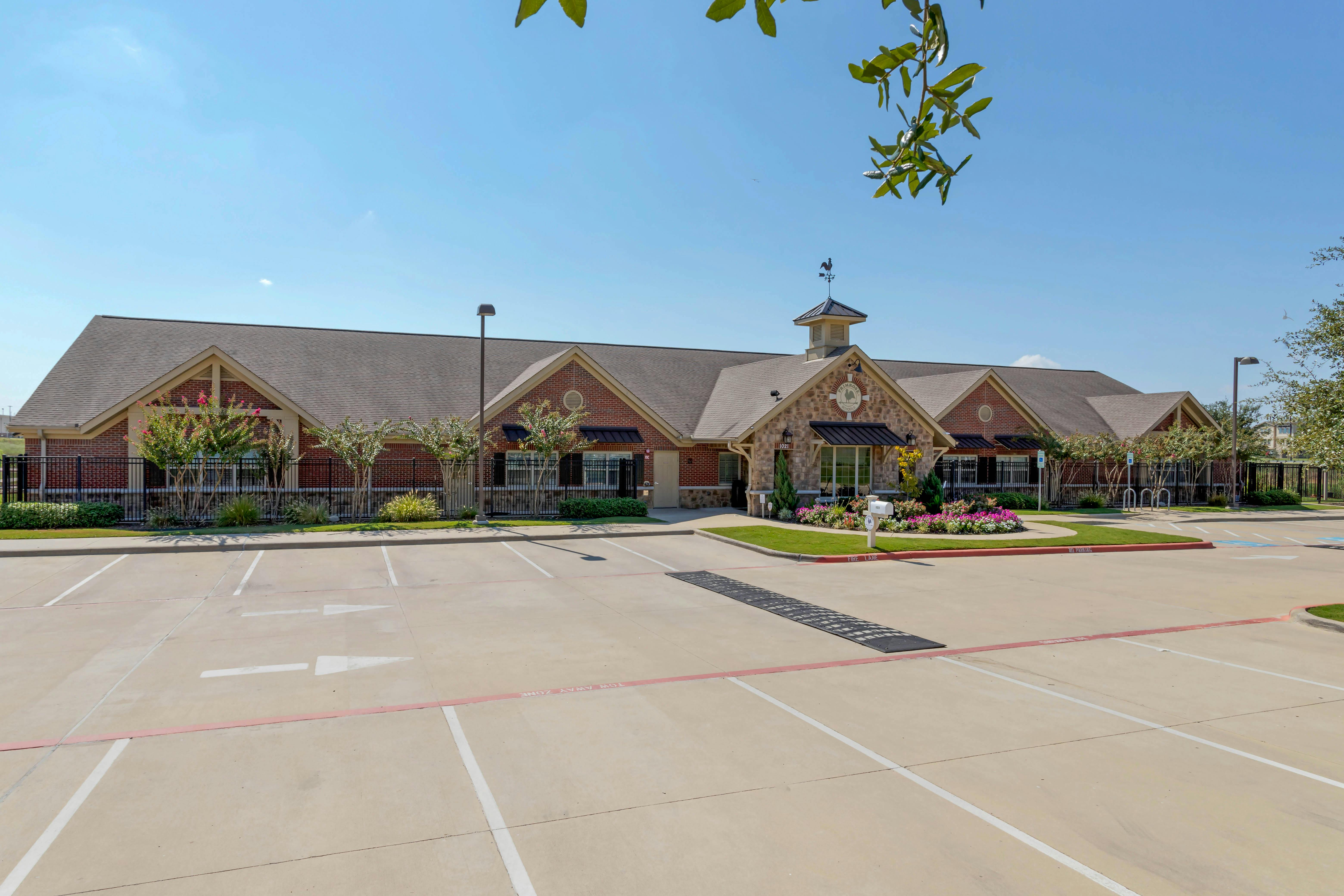A school building with a parking lot in front