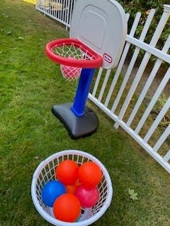 Toy basketball hoop with a basket of colorful balls