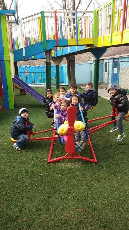 Children playing on a seesaw and other playground equipment