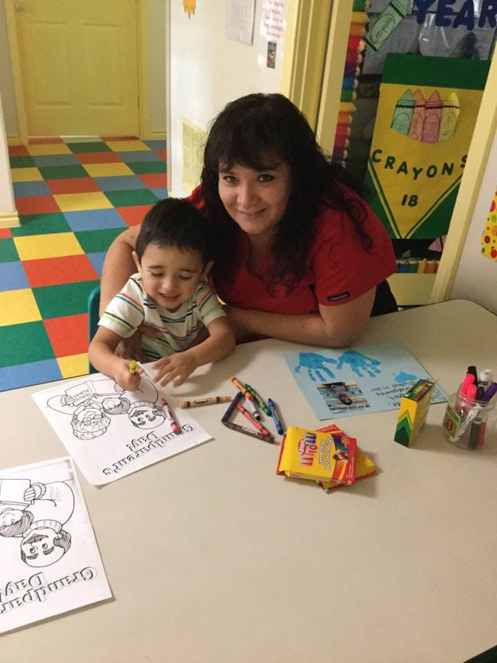 Person and child coloring at a table