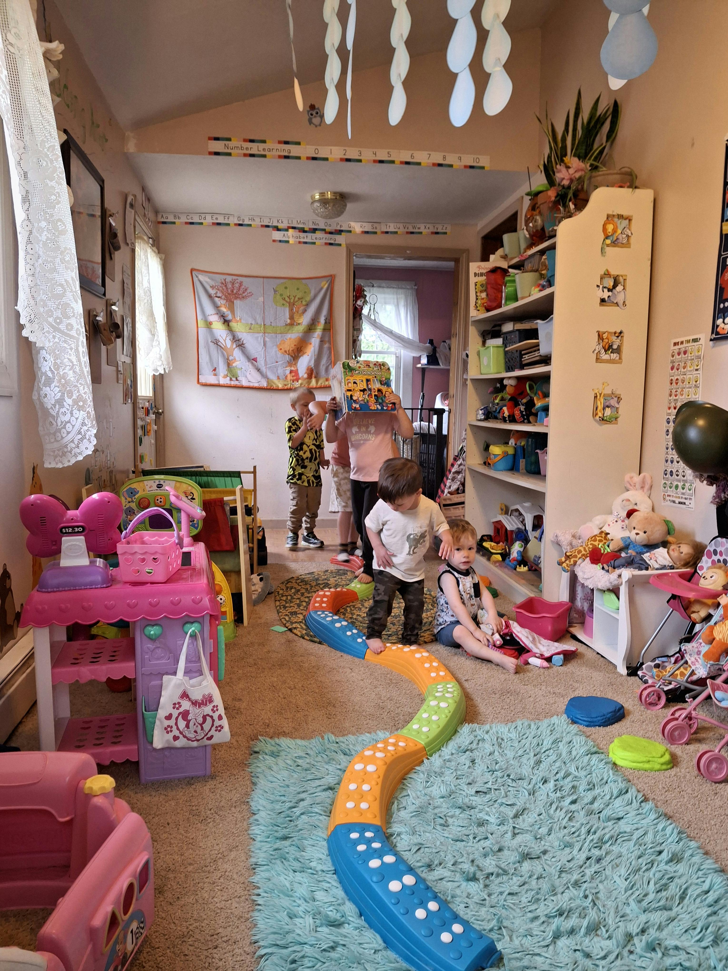 Children playing in a room with toys and a balance beam