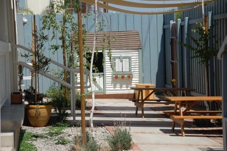 Playhouse and picnic tables in a backyard