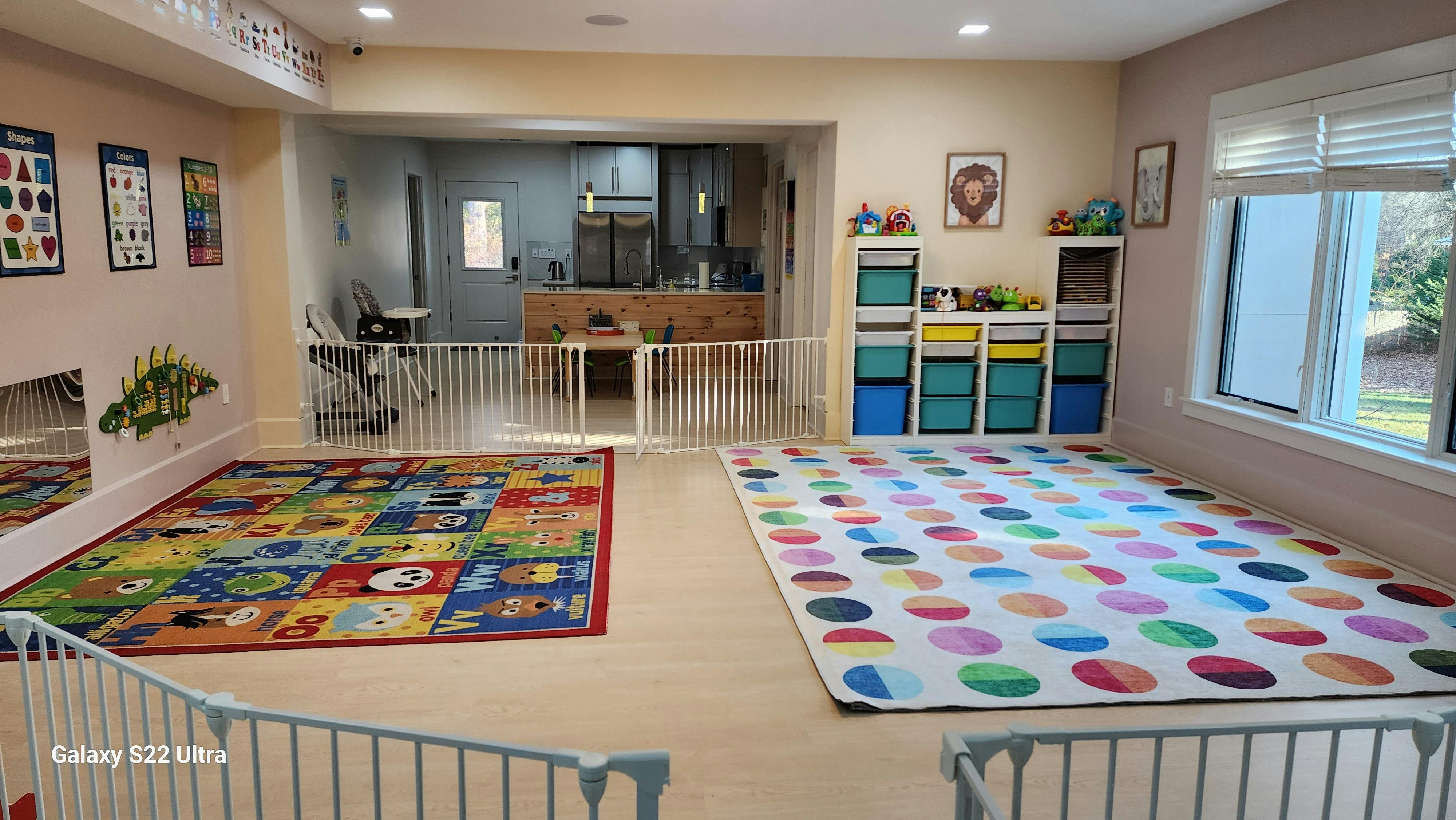 Playroom with two colorful rugs and a safety gate