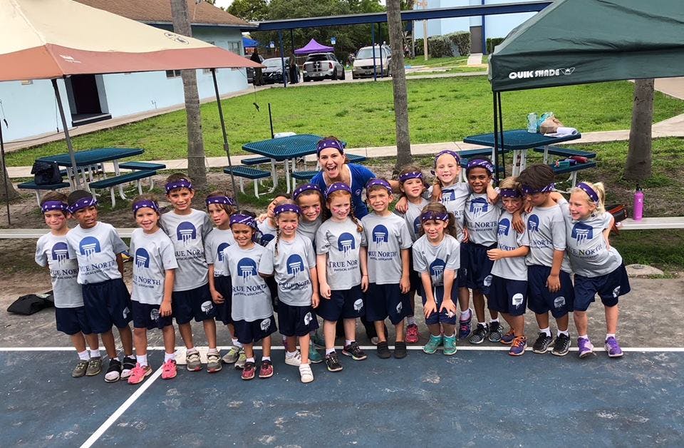 Adult and group of children in matching shirts and headbands