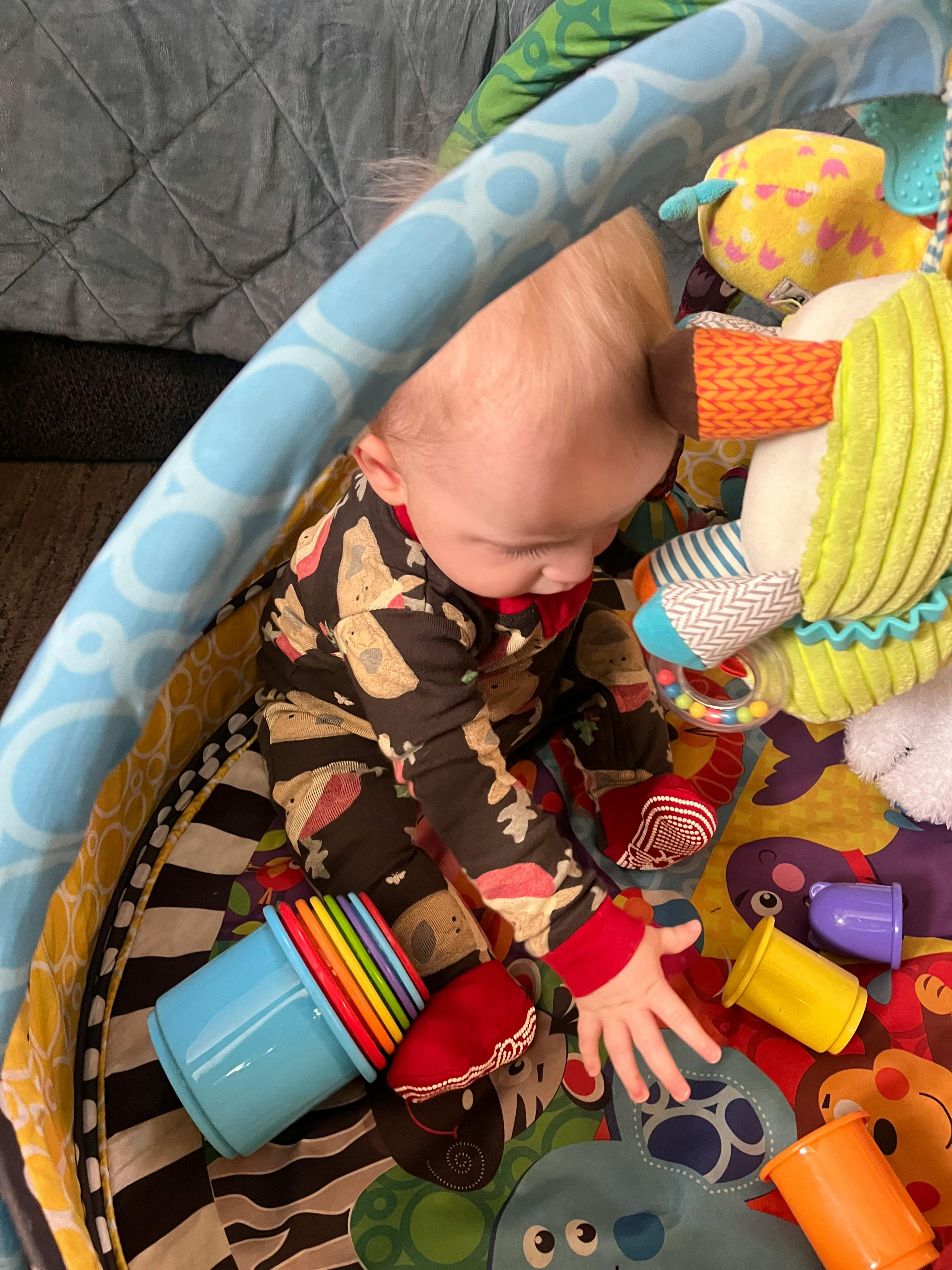 Child playing with toys on a colorful mat