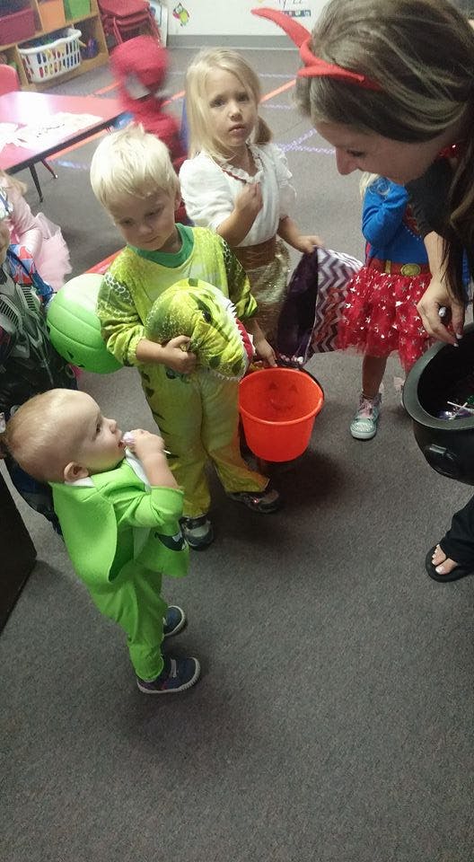 Adult and children in costumes holding buckets