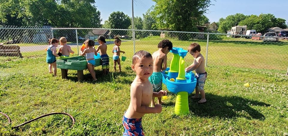 Children playing with water tables outdoors