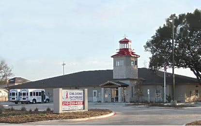 Building with a lighthouse-style tower and a sign that reads "Children's Playhouse"