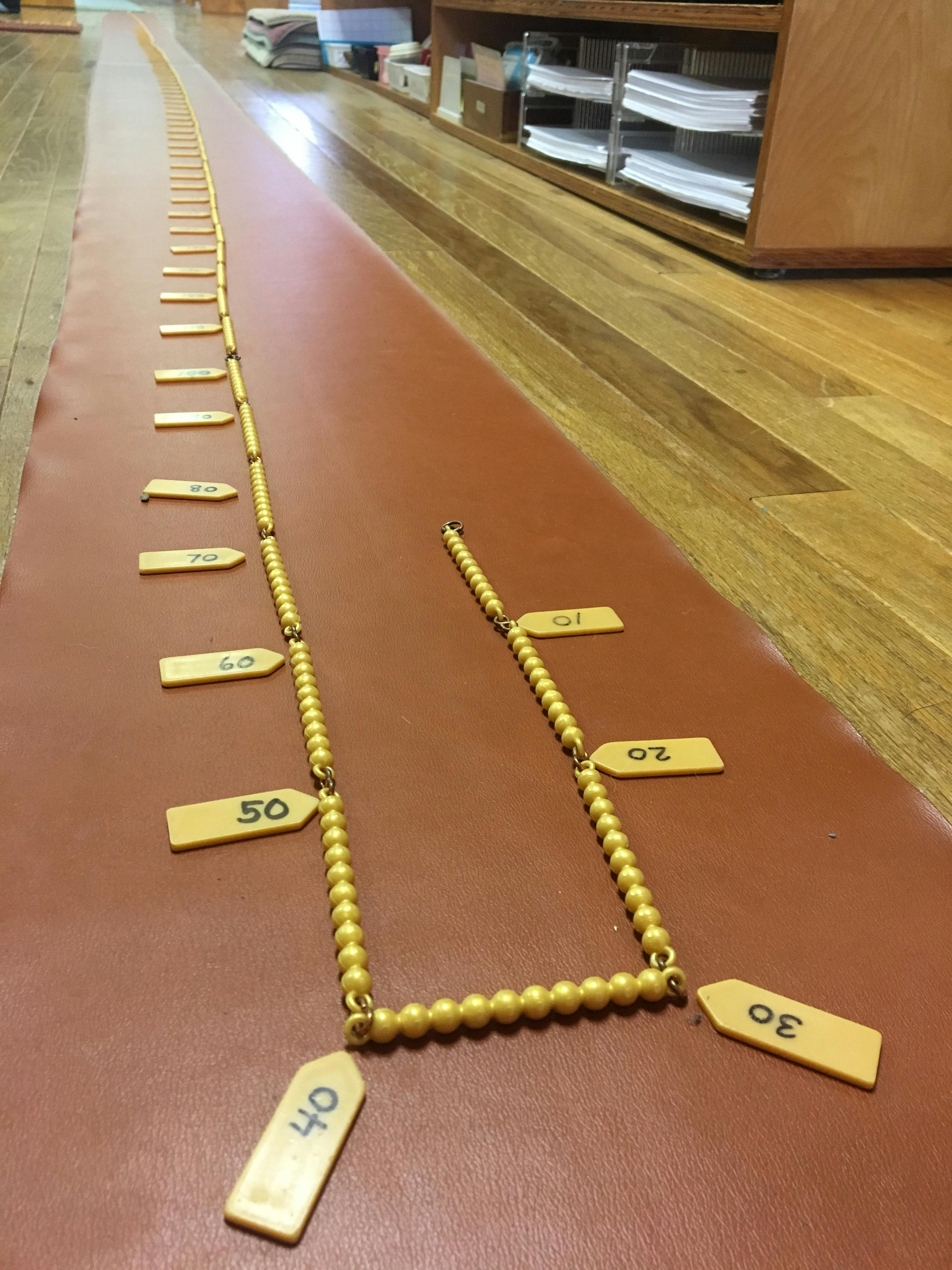 Long bead chain with numbered tags on a mat