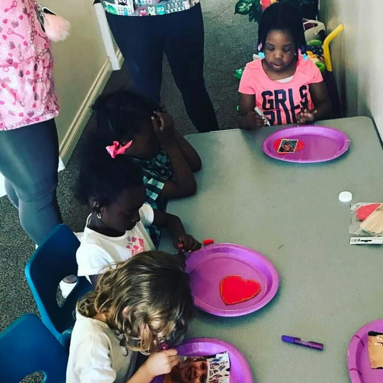 Children sitting at a table with purple plates
