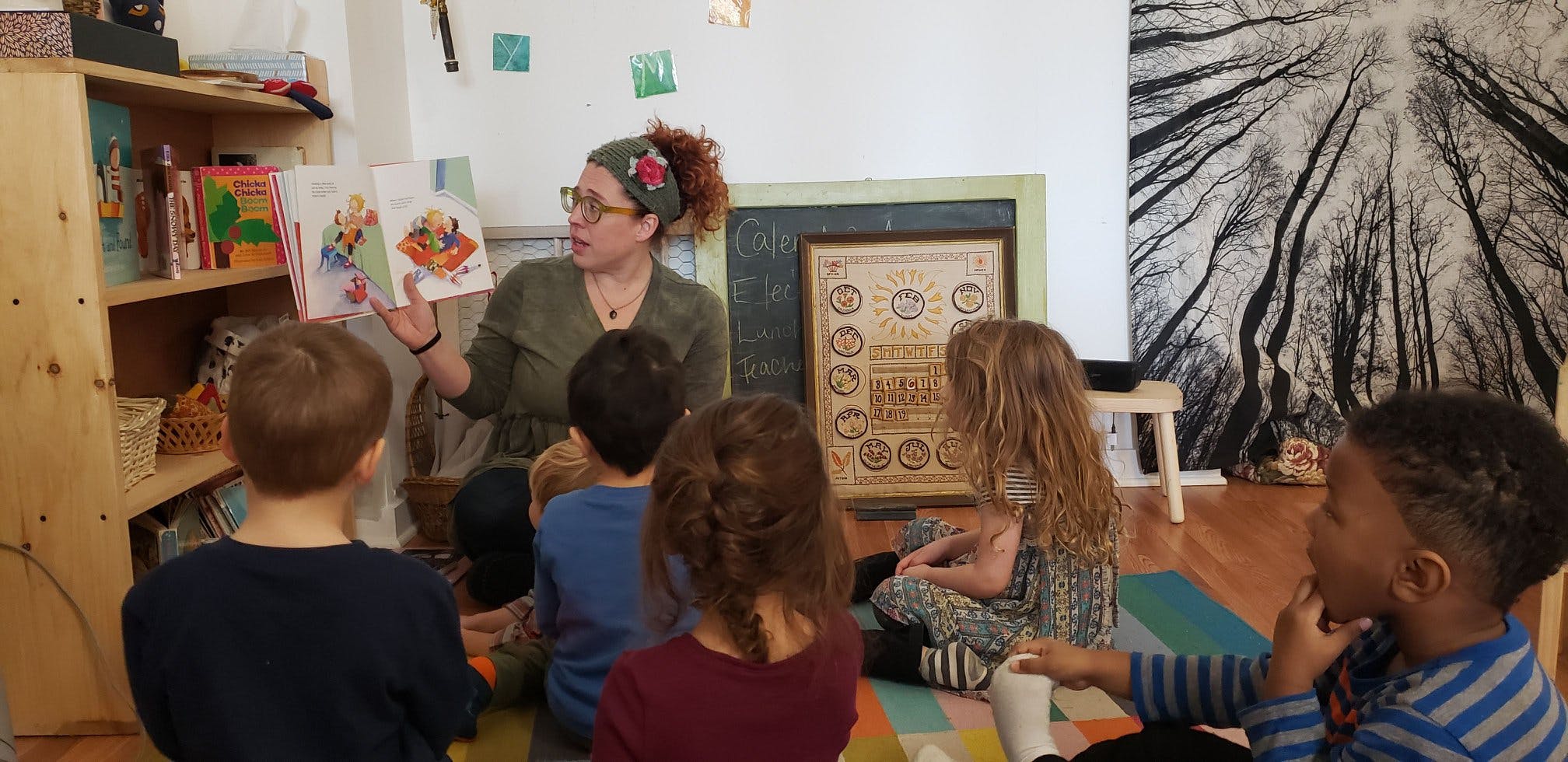 Person reading a book to a group of children in a classroom