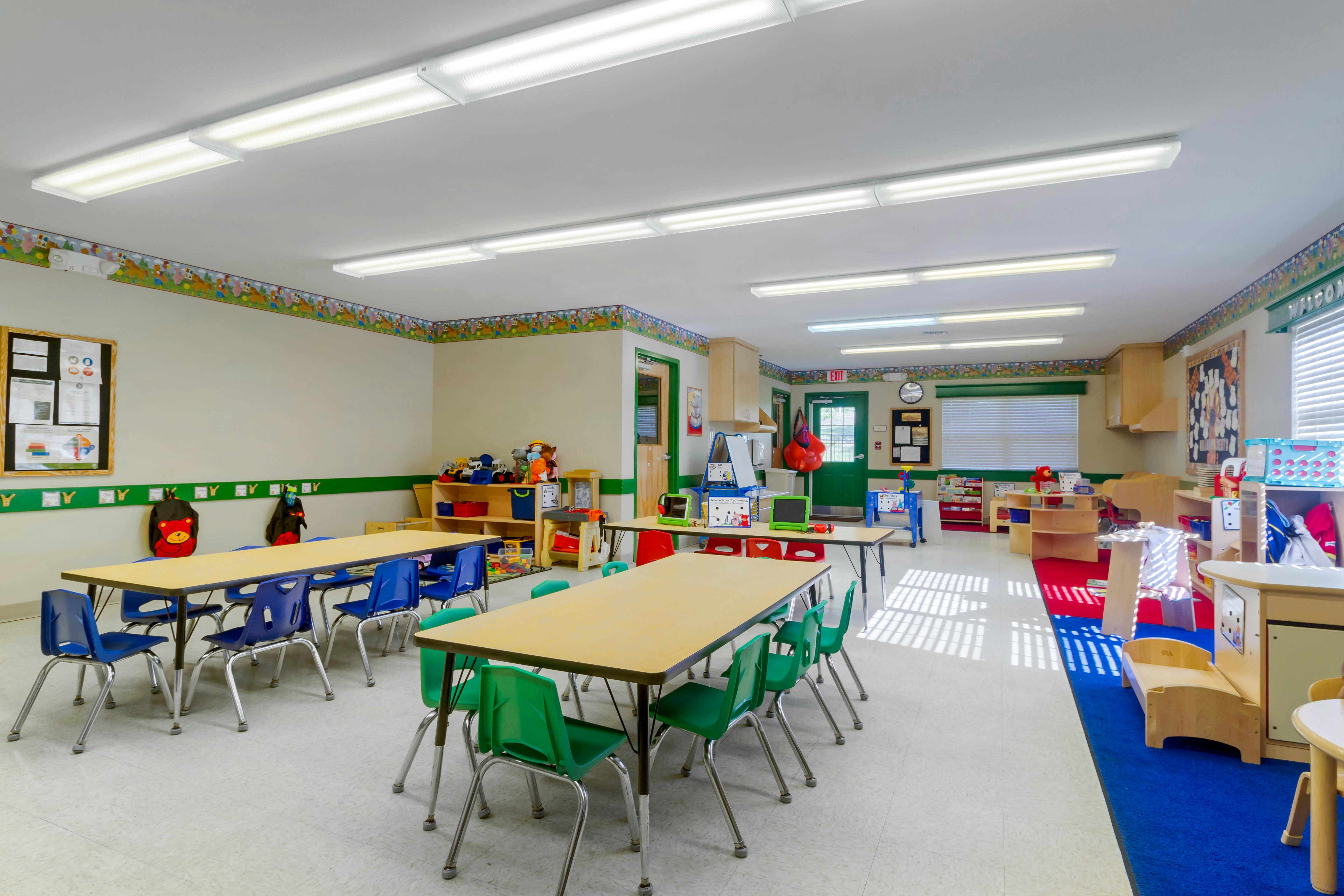 A colorful classroom with tables and chairs for young children