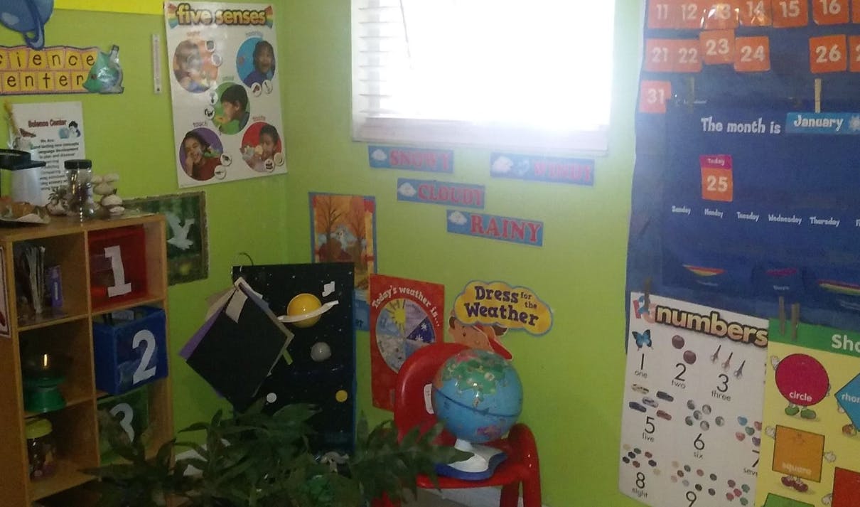 Classroom with educational posters, globe, and shelving unit