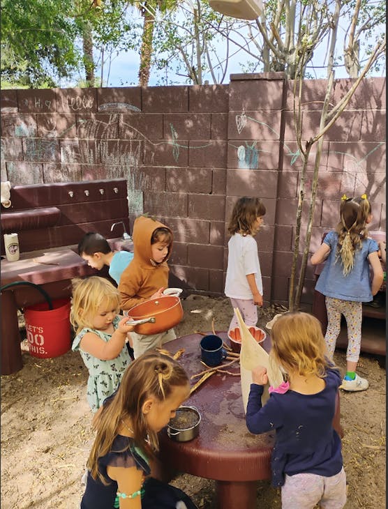 Children playing with pots and pans outdoors