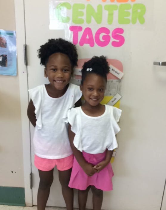 Two children standing in front of a door with "CENTER TAGS" on it