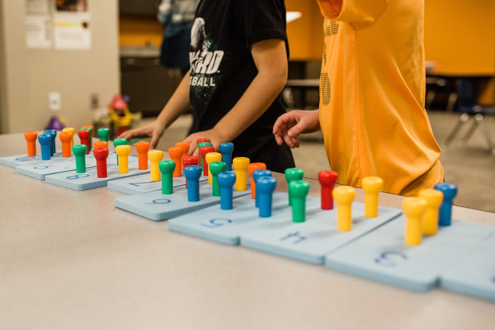 Two children playing with colorful pegboards
