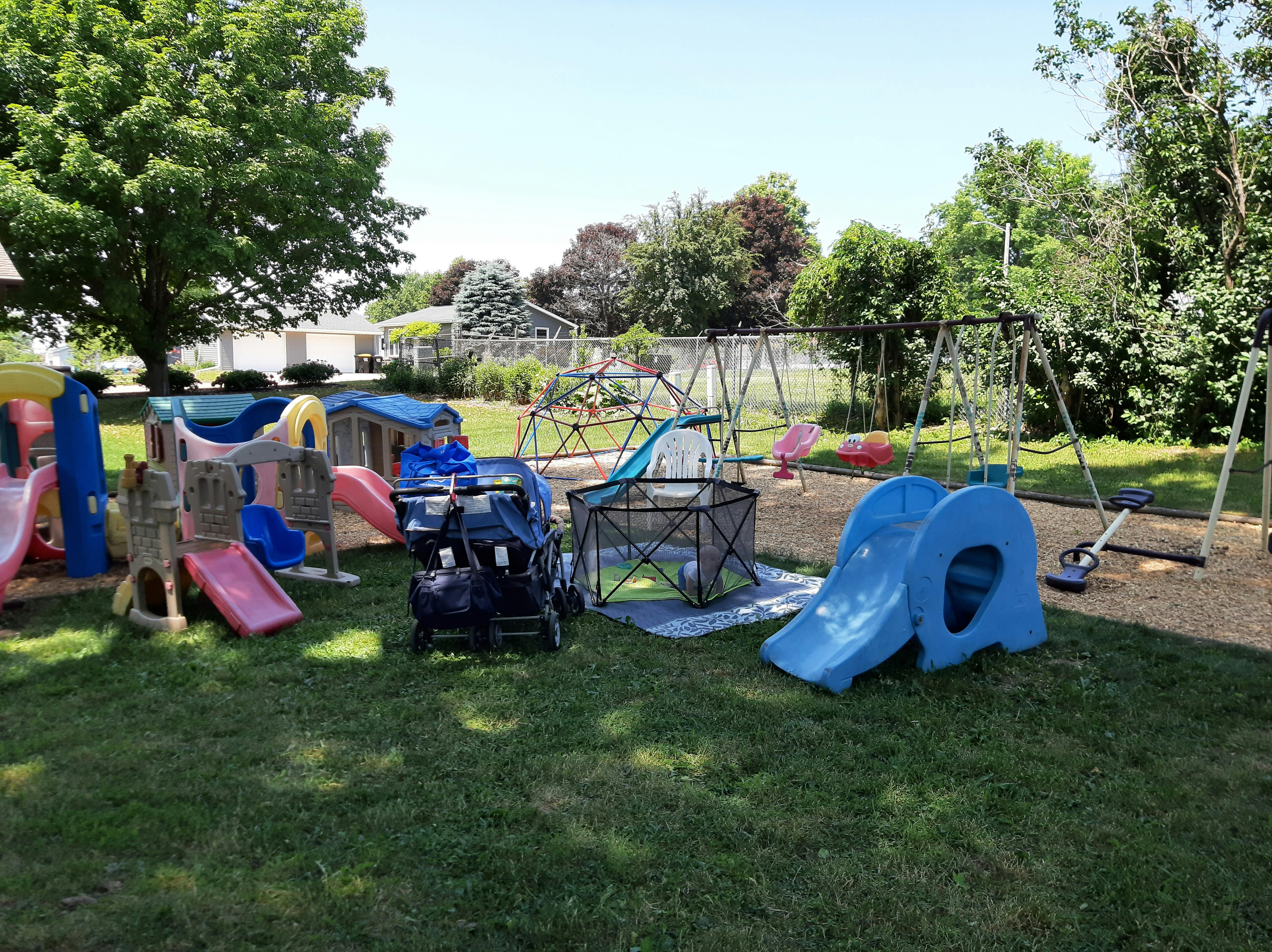 Outdoor playground with slides, swings, and play structures on grass
