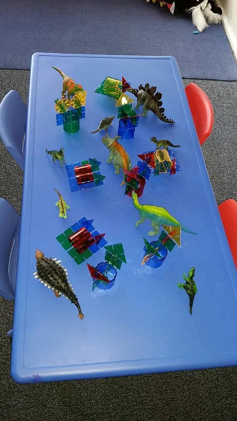 Toy dinosaurs and colorful building blocks on a blue table