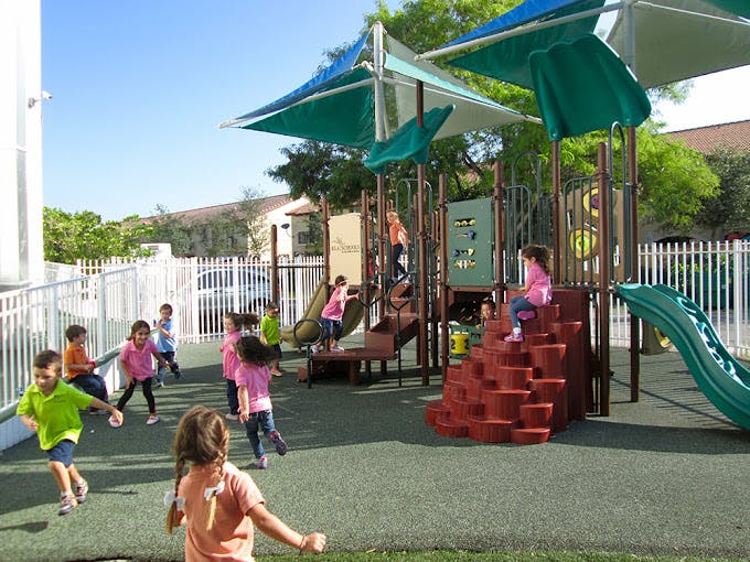 Children playing on a playground with slides and climbing structures