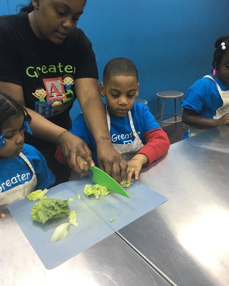 Adult and child cutting lettuce on a chopping board