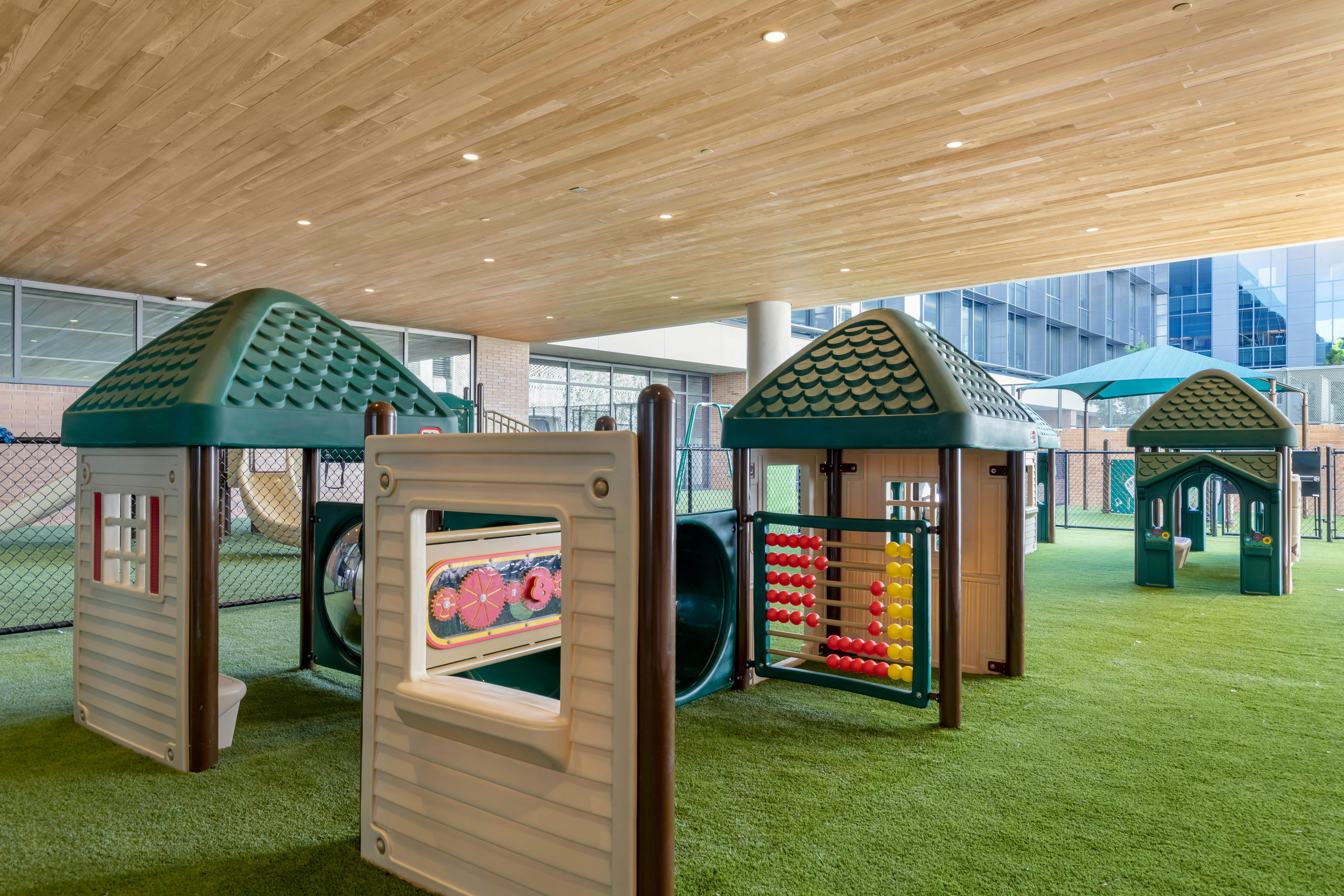 Indoor playground with multiple playhouses and green turf
