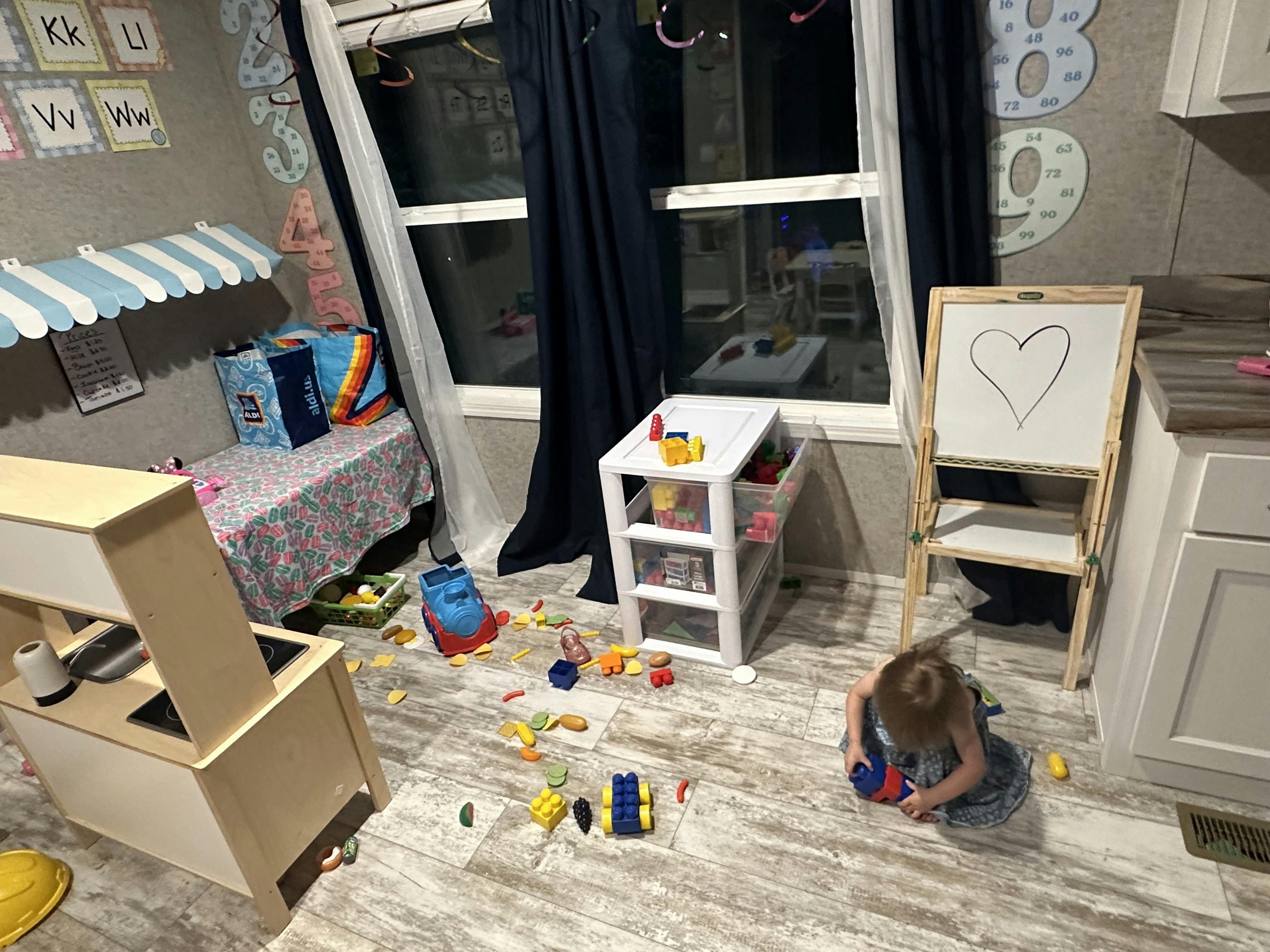 Child playing with building blocks on the floor in a playroom