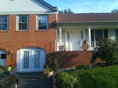 Brick house with white siding and a front porch