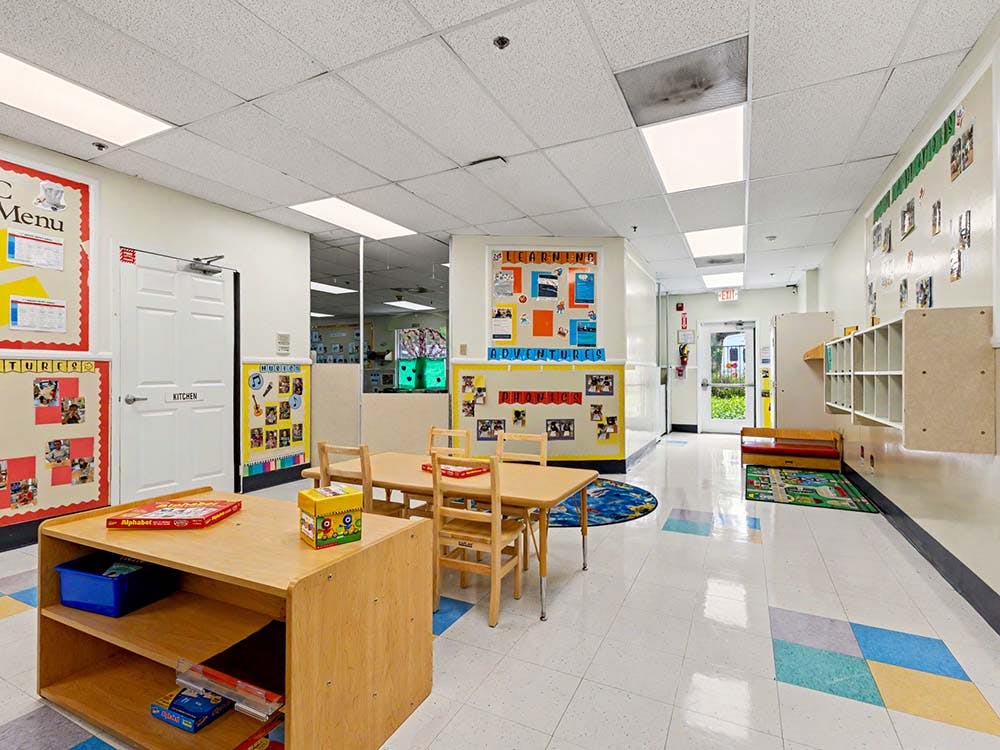 Classroom with small tables and chairs, shelves, and decorations on the walls