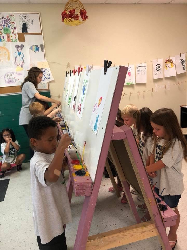 Children painting at easels in a classroom