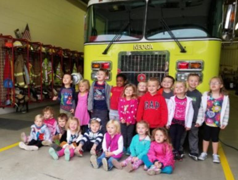 Group of children posing in front of a fire truck