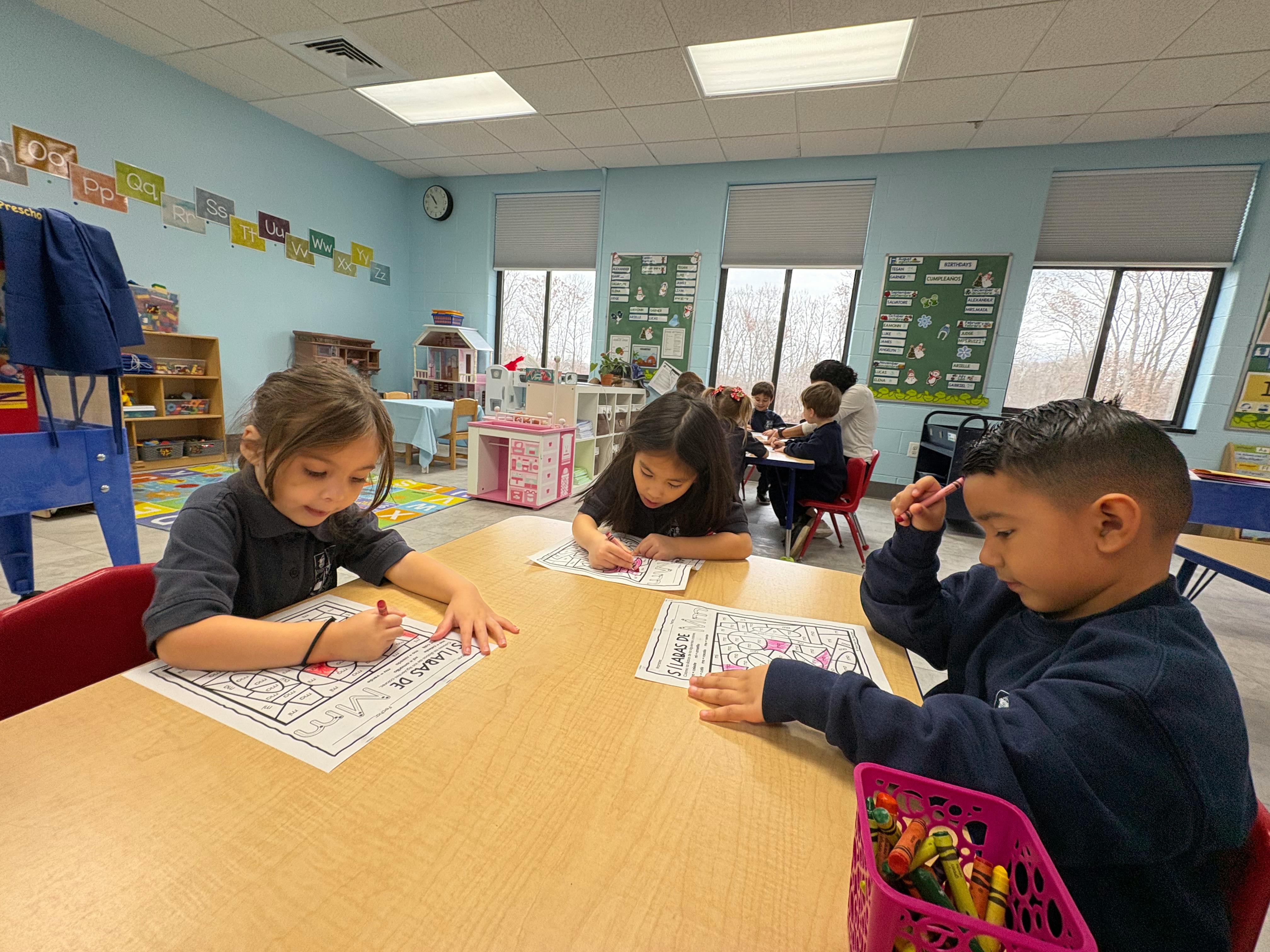 Children coloring at a table in a classroom