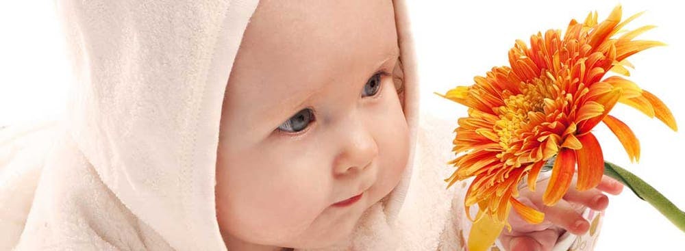 Child holding an orange flower