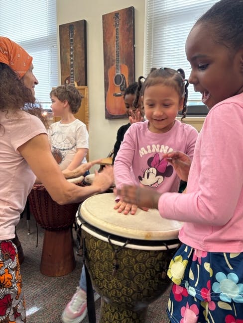 People playing drums in a classroom