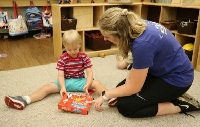 Adult and child playing with a toy on the floor